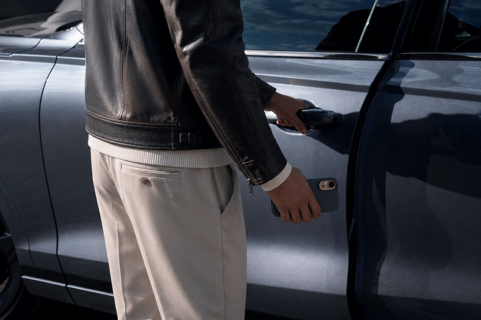 Person approaching a company car with phone in hand