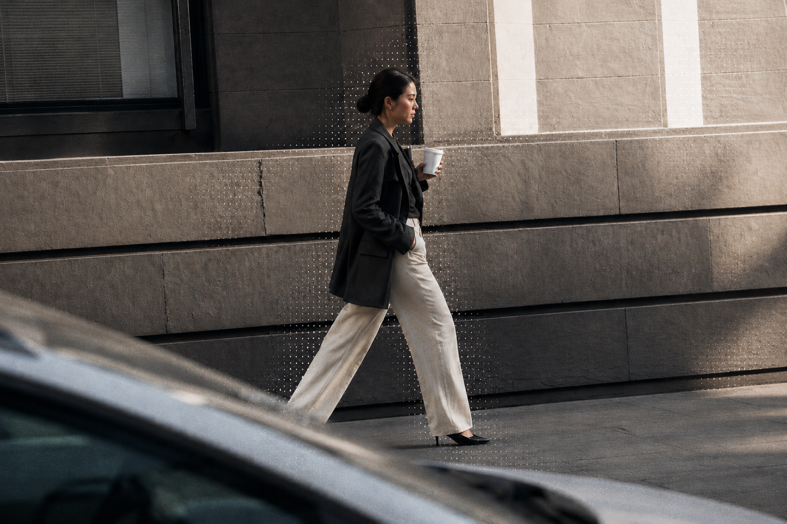 Professional woman walking in the city with a coffee